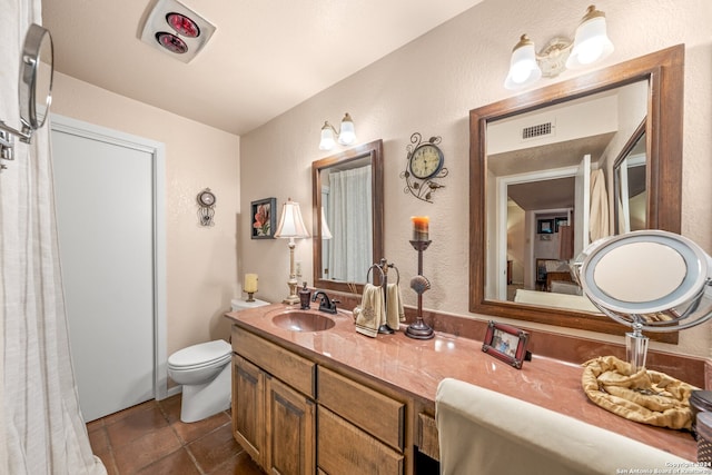 bathroom featuring tile patterned flooring, toilet, and vanity