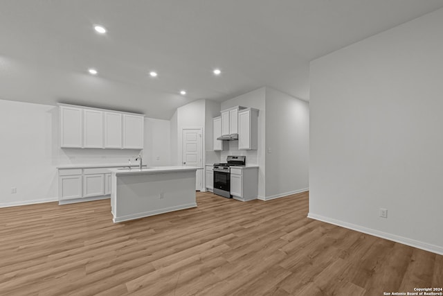 kitchen with a kitchen island with sink, white cabinets, light hardwood / wood-style floors, and stainless steel range oven