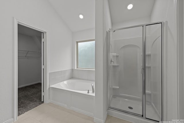 bathroom with vaulted ceiling, tile patterned floors, and independent shower and bath