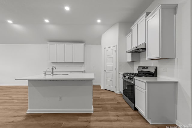 kitchen featuring an island with sink, sink, white cabinets, stainless steel gas range, and light hardwood / wood-style flooring