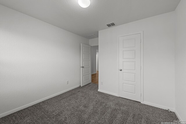 unfurnished bedroom featuring dark colored carpet