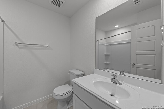 bathroom with vanity, tile patterned floors, a shower, and toilet