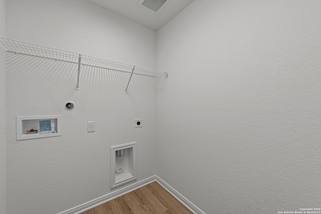 washroom with wood-type flooring, hookup for a washing machine, and electric dryer hookup