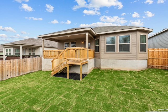 back of property featuring a wooden deck and a lawn