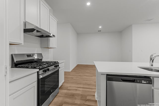 kitchen with sink, stainless steel appliances, white cabinets, and light wood-type flooring