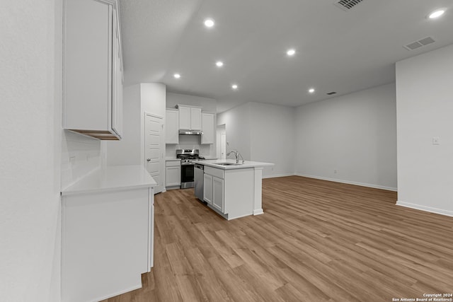 kitchen featuring sink, light hardwood / wood-style flooring, a center island with sink, stainless steel range, and white cabinets