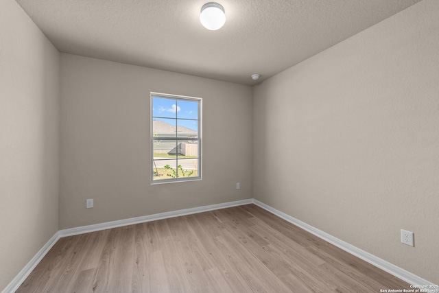 unfurnished room featuring light hardwood / wood-style floors and a textured ceiling