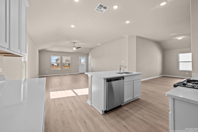 kitchen with stainless steel dishwasher, ceiling fan, white cabinets, an island with sink, and lofted ceiling