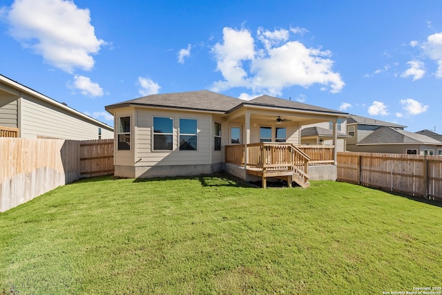 back of house with ceiling fan, a deck, and a yard