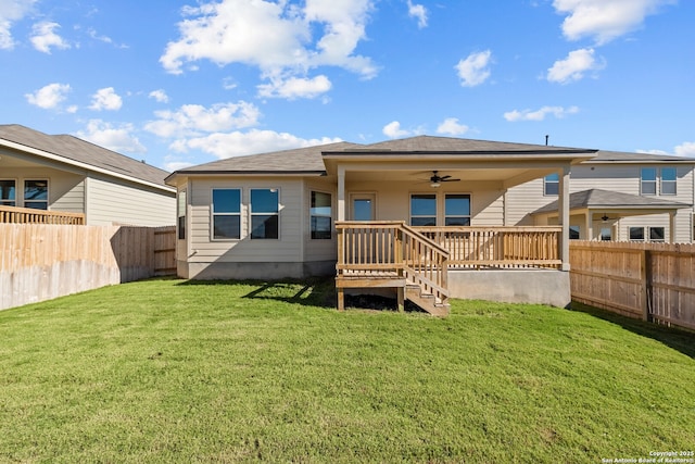 rear view of property with ceiling fan, a deck, and a yard