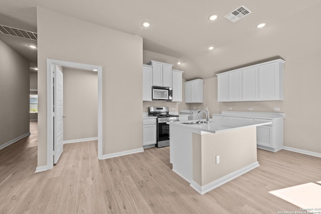 kitchen featuring white cabinetry, stainless steel range oven, a center island with sink, and sink