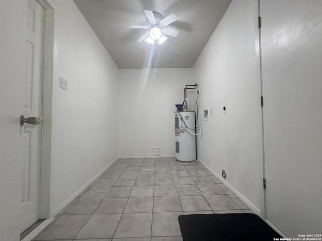 tiled empty room with a textured ceiling, electric water heater, and ceiling fan