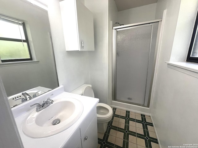 bathroom with vanity, toilet, and a shower with shower door