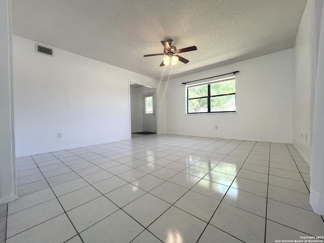 unfurnished room with light tile patterned floors, a textured ceiling, and ceiling fan