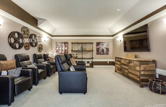 carpeted cinema room with vaulted ceiling