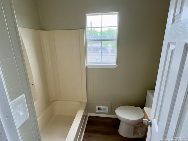 full bathroom with shower / washtub combination, toilet, vanity, tile walls, and wood-type flooring