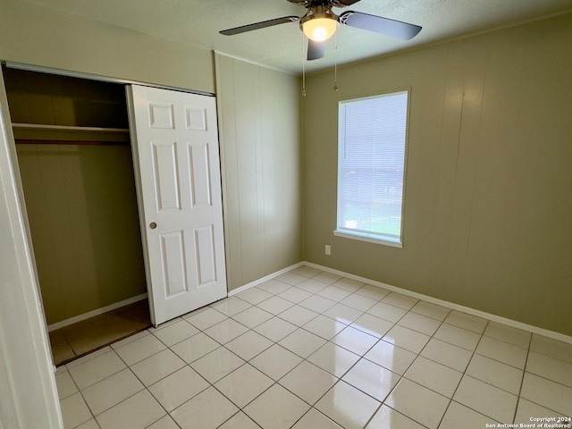 unfurnished bedroom featuring a closet, light tile patterned floors, and ceiling fan