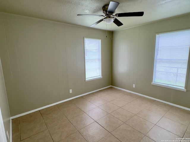 tiled empty room with a textured ceiling and ceiling fan