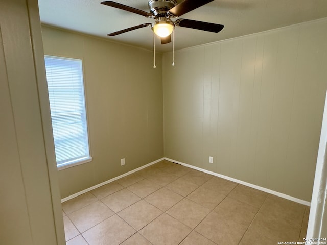 tiled spare room with ceiling fan