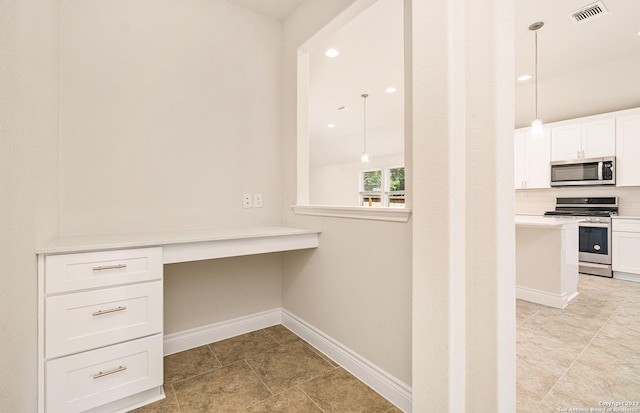 interior space with stainless steel appliances, kitchen peninsula, decorative light fixtures, decorative backsplash, and white cabinets