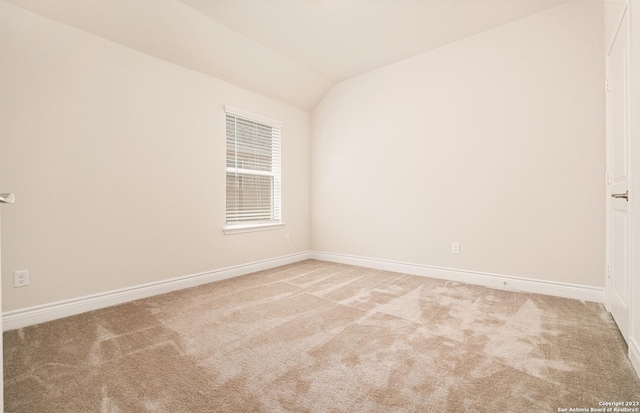 empty room featuring carpet and lofted ceiling