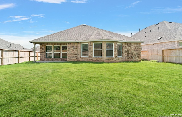 rear view of property featuring a yard