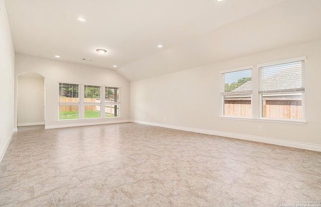 unfurnished room with vaulted ceiling