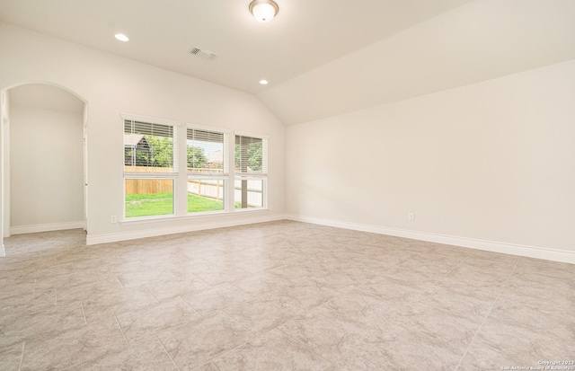 spare room featuring lofted ceiling