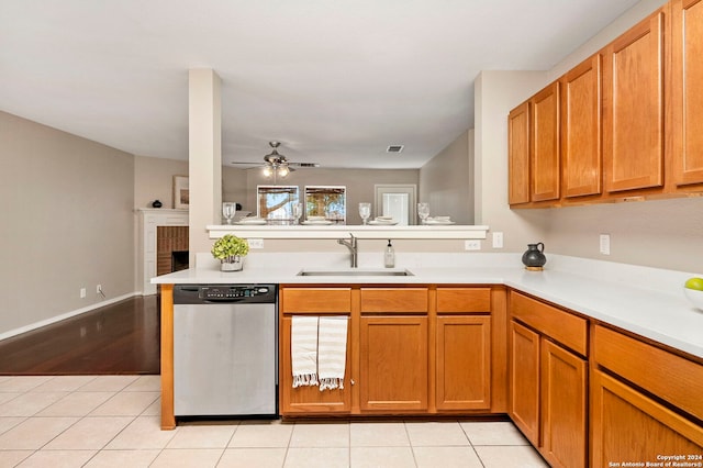 kitchen with dishwasher, a fireplace, sink, kitchen peninsula, and ceiling fan