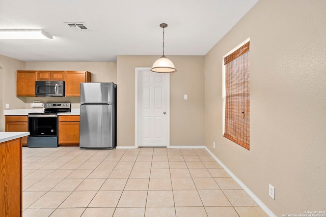 kitchen with hanging light fixtures, light tile patterned floors, and stainless steel appliances