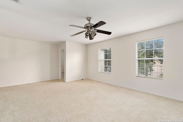 empty room with ceiling fan and light colored carpet