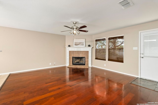 unfurnished living room featuring ceiling fan, a fireplace, and hardwood / wood-style flooring