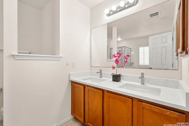 bathroom featuring toilet, vanity, tile patterned flooring, and walk in shower