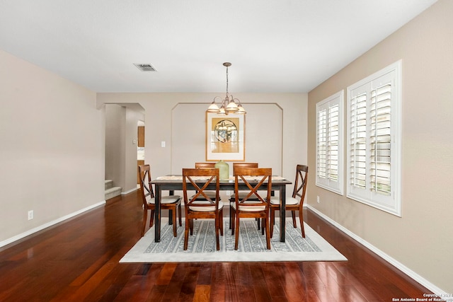 dining room featuring dark hardwood / wood-style flooring and a notable chandelier