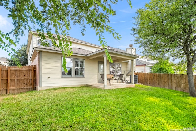 back of house featuring a patio area and a lawn