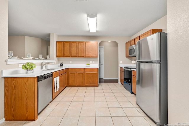 kitchen with light tile patterned flooring, stainless steel appliances, and sink