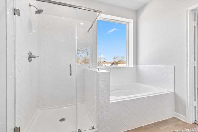 bathroom with plus walk in shower and hardwood / wood-style flooring