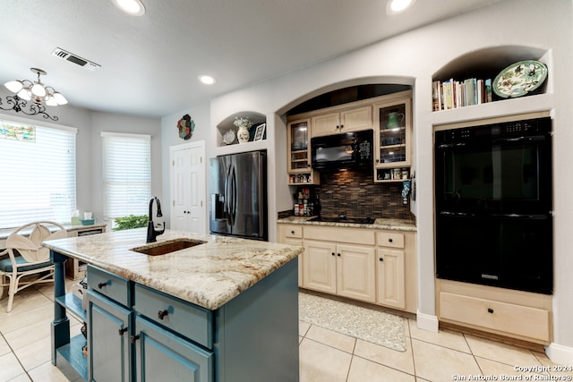 kitchen with light tile patterned flooring, black appliances, a center island with sink, and backsplash