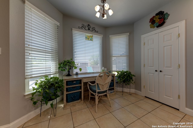 office featuring a notable chandelier, light tile patterned floors, and plenty of natural light