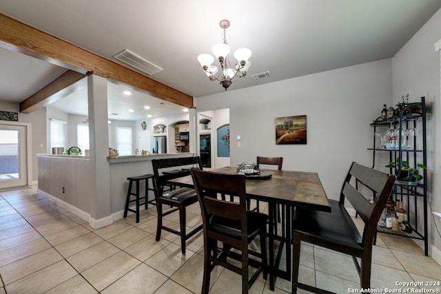 tiled dining area featuring a chandelier and beam ceiling