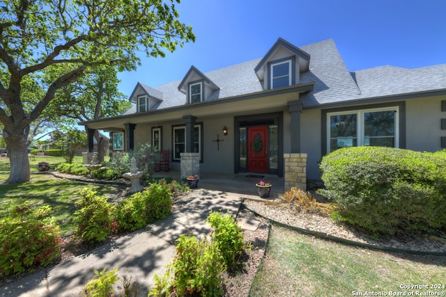 cape cod house featuring a porch