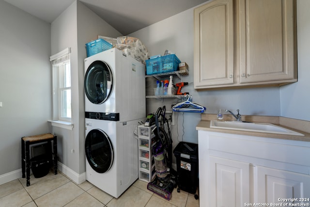 washroom with sink, stacked washing maching and dryer, and light tile patterned floors