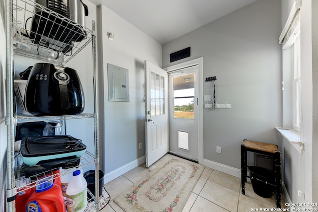 interior space with light tile patterned floors and electric panel