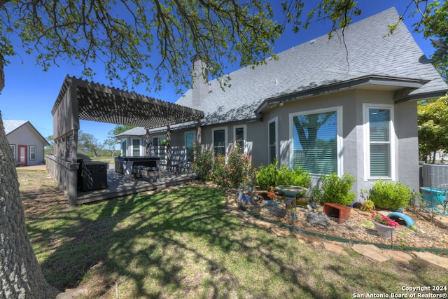 back of house with central air condition unit, a patio area, a lawn, and a pergola