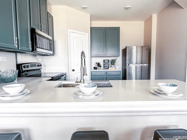 kitchen with stainless steel appliances, a kitchen breakfast bar, and sink