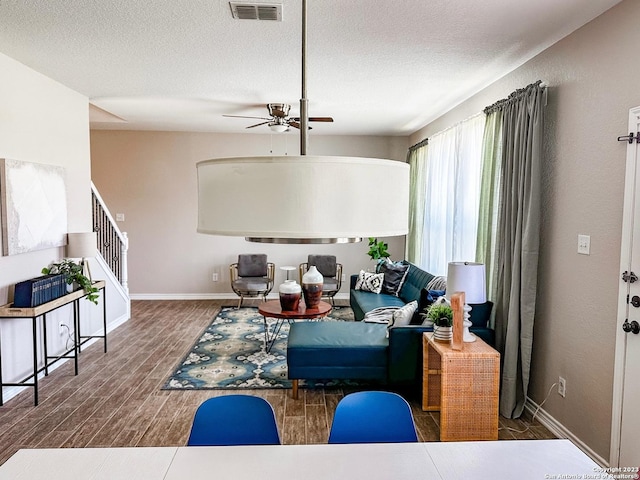 living room with ceiling fan and a textured ceiling