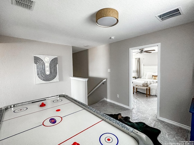 game room featuring ceiling fan and a textured ceiling