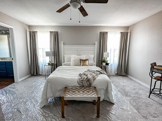 bedroom featuring ceiling fan, sink, carpet floors, and a textured ceiling