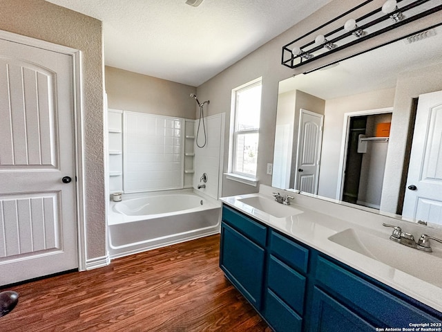 bathroom with vanity, wood-type flooring, bathing tub / shower combination, and a textured ceiling