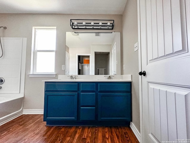 bathroom featuring hardwood / wood-style flooring,  shower combination, and vanity